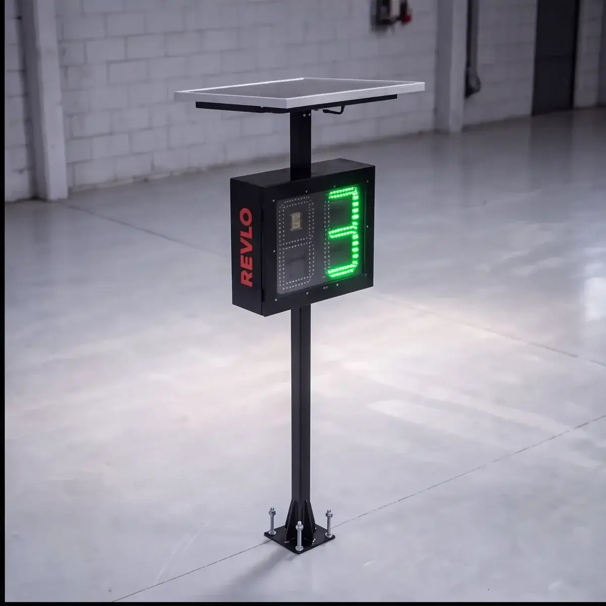 Lombada eletrônica sobre coluna chumbada no piso, com painel solar no topo e a velocidade em LED verde